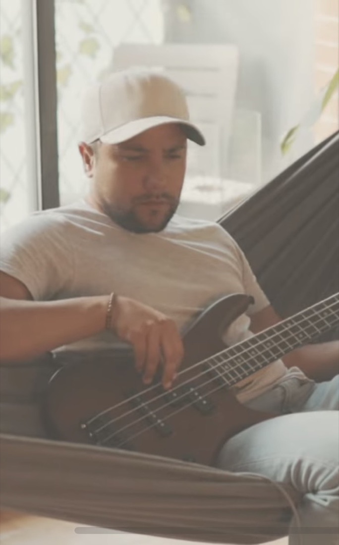 Leon Gabriel playing bass in a hammock